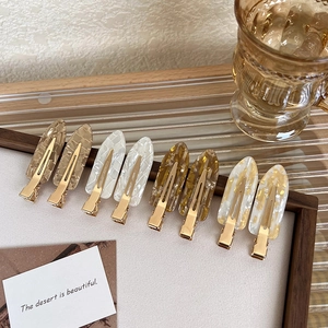 Colorful resin seamless hair clips with marble texture on an elegant wooden tray