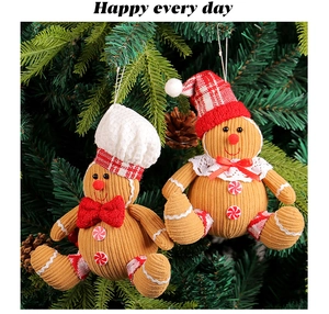 Close-up of plush gingerbread man ornaments with festive hats on a green Christmas tree