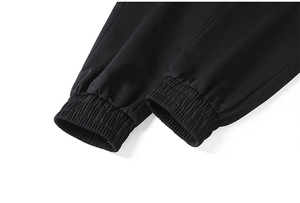Dettaglio dei polsini elastici a coste sui pantaloni sportivi neri da uomo