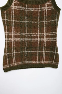 Detailed view of the checkered knit texture on the dark brown and army green vest