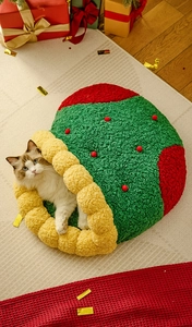 Detail eines warmen Weihnachts-Katzenbetts aus weichem Fleece mit festlichen roten Pompons