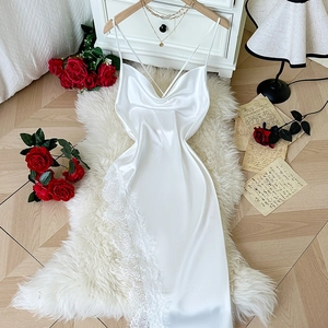 Elegant white satin slip dress with lace trim and spaghetti straps on soft white faux fur