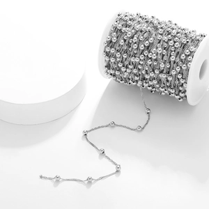 Detail of silver stainless steel water wave bead chain wound on a spool for DIY jewelry