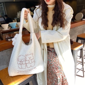 Detail of white plush tote bag with brown bear embroidery and soft faux fur texture
