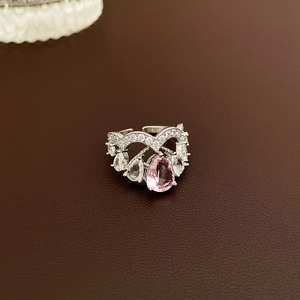 Macro shot of silver ring with pink pear-cut gemstone and white pavé zircon stones