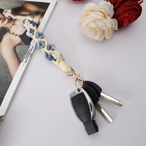 Close-up of handmade bohemian woven flower keychain with gold lobster clasp and car key