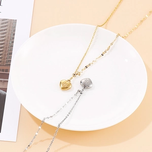 Elegant gold and silver heart necklaces with sun engraving on a white plate