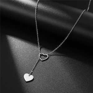 Detail of silver heart Y-shaped necklace with polished pendant and open heart link