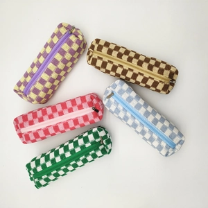 Top view of five knitted checkerboard pencil cases in various vibrant color combinations
