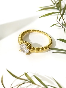 Detail of 18K gold bubble ring band featuring a round brilliant-cut solitaire zircon