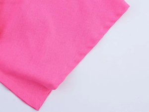 Gros plan détaillé sur la texture du lin rose et l'ourlet piqué de haute qualité du vêtement