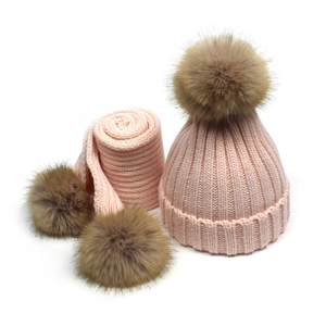 Detailed knit texture of pink winter hat and scarf set with fluffy brown pom-poms
