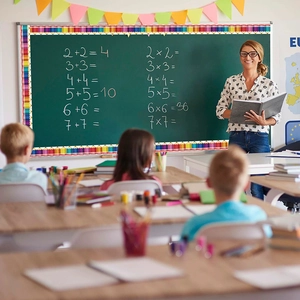 Colorful pencil bulletin board border stickers on a classroom chalkboard with teacher