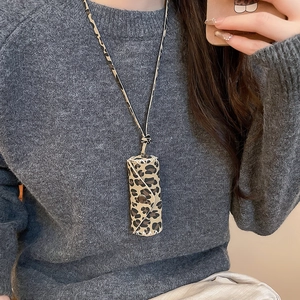 Macro view of leopard print lipstick holder pendant with stitching and snap button