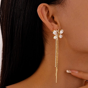Close-up of golden butterfly tassel earrings with sparkling zircon crystals on model