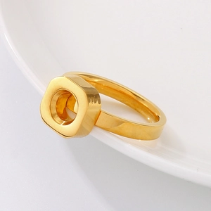 Macro shot of gold nut-shaped ring detailing the unique hexagonal metal texture and finish