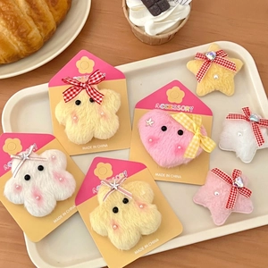 Plush star and cloud hair clips set with bows and pearls on a decorative display tray