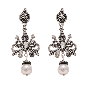 Vintage silver bow earrings with sparkling rhinestones and white pearls on white backdrop
