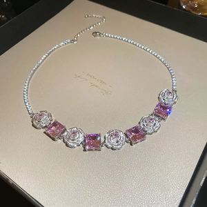 Detail view of flower necklace featuring pink square zircon stones and rose-shaped charms