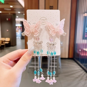 Close-up of pink embroidered butterfly hair clips with long beaded tassels for girls