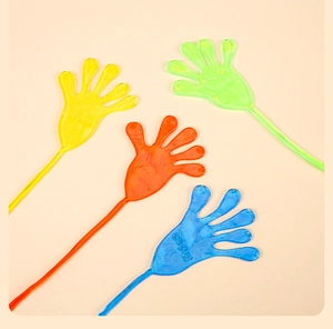Flat lay of colorful elastic sticky hands in yellow, green, orange, and blue TPR material