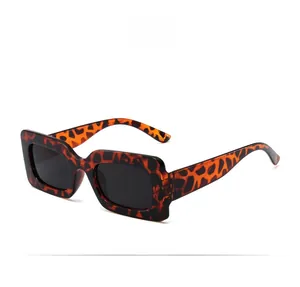 Close-up of retro square sunglasses featuring leopard print frame and black lenses
