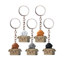 Detailed view of 3D cartoon puppy figurines in miniature cardboard boxes as keychains