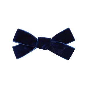 Detailed close-up of a deep blue velvet bow hair clip with fine texture on white background