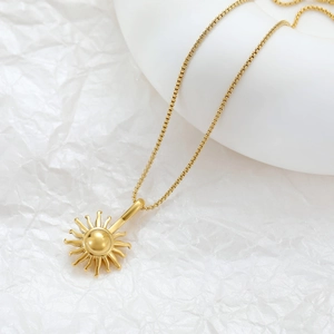 Elegant gold sunburst pendant necklace with minimalist chain on a clean white background