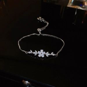 Detail of zircon flower bracelet with adjustable slider clasp and silver metal finish