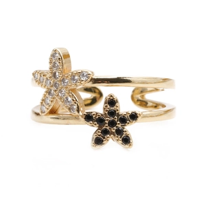 Adjustable gold starfish ring with black and white zircon stones on a white background
