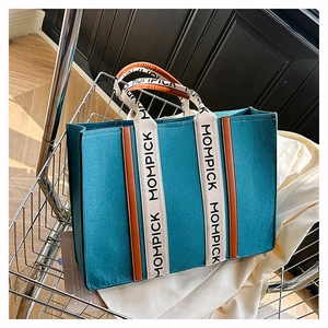 Detailed shot of teal felt tote bag with brown trim and MOMPICK branded textile straps