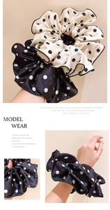 Close-up of beige and black polka dot silk scrunchies with ruffled edge detail