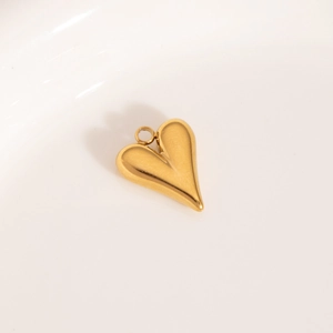 Detailed close-up of a 3D heart-shaped gold stainless steel pendant with a polished finish