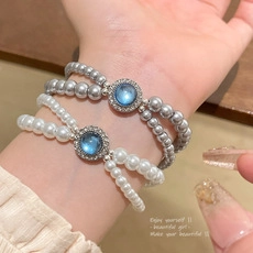 Close-up of double-layer pearl bracelets with sky blue gemstone and crystal detailing