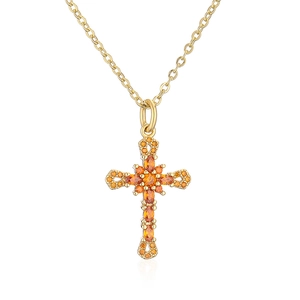 Macro shot of 18K gold-plated cross pendant featuring micro-set orange zircon stones