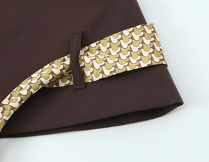 Détail du tissu tissé marron foncé avec une ceinture à motifs géométriques élégante