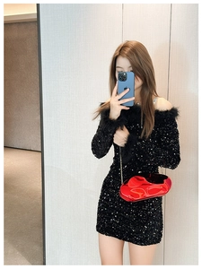 Close-up of a bright red glossy irregular acrylic clutch bag with golden chain strap