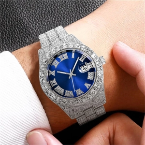 Macro view of iced-out silver watch with blue sunburst dial and roman numerals