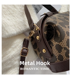 Detail of vintage brown monogram bag showing glossy gold lobster clasps and leather straps