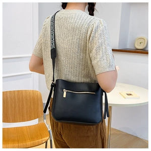 Detail of the back zipper pocket and patterned strap on a black large capacity tote bag