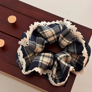 Plaid scrunchie in deep blue with white lace trim on vintage wooden background