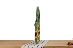 Side view of handmade crochet tote bag featuring sunflower pattern on wooden surface