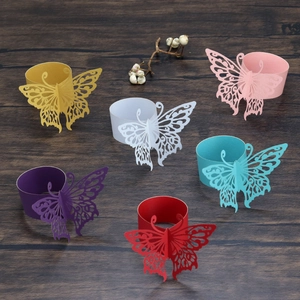 Detail of hollow butterfly napkin rings in various vibrant colors on wood background