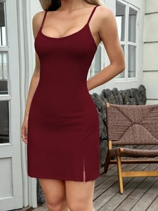 Detail shot of the side slit and hem on a sexy burgundy bodycon mini camisole dress