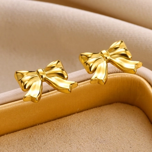 Polished 18K gold-plated stainless steel bow earrings displayed in a luxury jewelry box