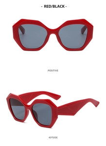 Close-up of red geometric frame sunglasses featuring faceted temple design and dark lenses