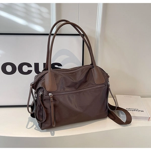Deep brown nylon tote bag with leather trim and front zipper pocket detail