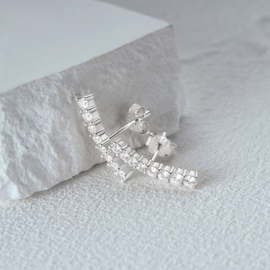 Detail view of S925 silver half moon earrings with rows of sparkling round clear crystals