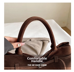 Detail of vintage brown frosted leather tote bag with smooth handle and silver metal buckle